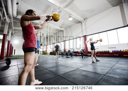 Women And Men Exercising In Gymnasium