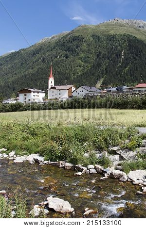 Galtur Tyrol Valley Village against a high hill and a torrent