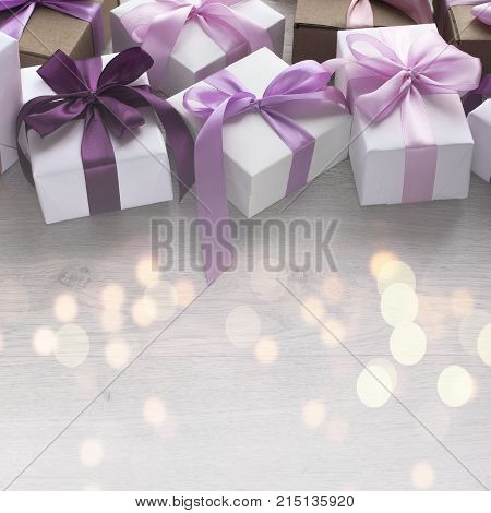 Gift boxes decorated with satin ribbon. The festive lights. Top view flat lay. Square