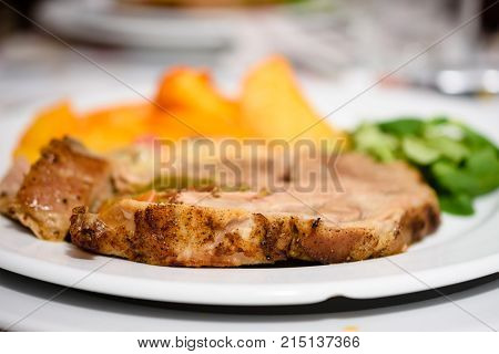 Delicious Pork Steak With Golden Baked Potatoes And Salad On White Plate
