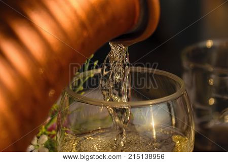 White Wine Being Poured Into Wine Glass At Sunset