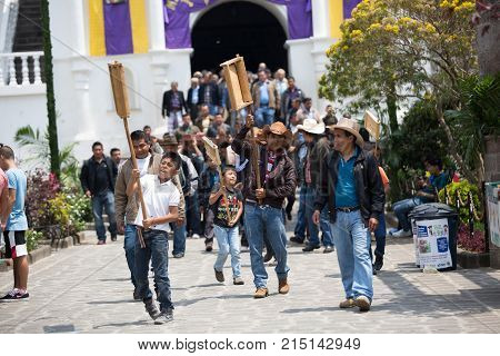 March 24,2016 San Pedro la Laguna, Guatemala: men holding up wooden ratchet during Easter Week procession