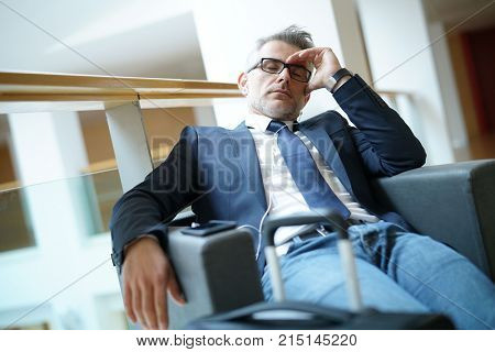 Businessman taking a nap in airport departure lounge