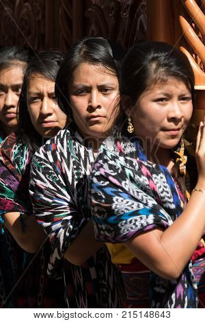 March 25, 2016 San Pedro la Laguna, Guatemala: mayan tzutujil women carrying a heavy float on the street of the small town during Easter holidays