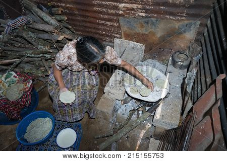 April 2, 2016 San Pedro la Laguna, Guatemala: an elderly tzutujil mayan woman is cooking tortillas on a wood fire