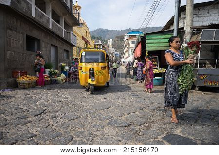 April 15, 2016 San Pedro la Laguna, Guatemala: a woman crossing the cobblestone street in the centre of the small Mayan town