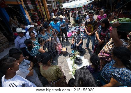 April 17, 2016 San Pedro la Laguna, Guatemala: people watching a man demonstrating a product in the local weekly farmers market