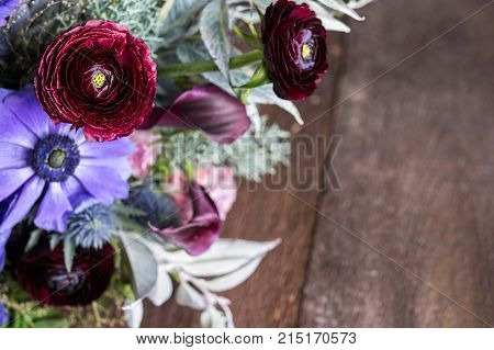 nature, romance, love concept. close up of bright buds of different flowers in great bunch, few of them are standing out because of intense maroon colour and light yellow centers