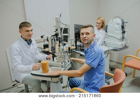 Young Beautiful Doctor/eye Specialist/optometrist In An Ophthalmologic Clinic Examines A Patient