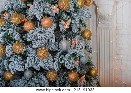 New Year tree with decorations near the fireplace