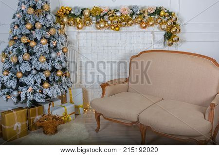 New Year tree with decorations near the fireplace and a beautiful sofa
