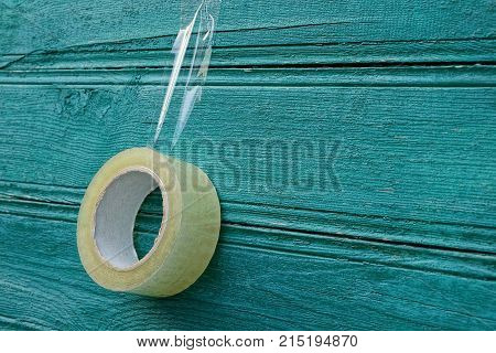 transparent scotch hanging on a green wooden wall