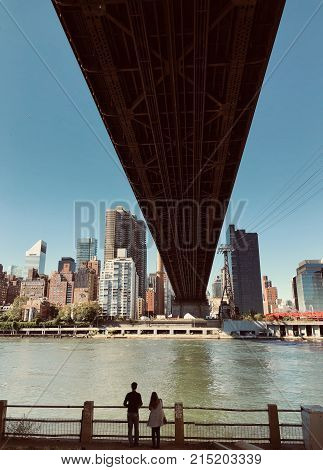 Two peoples observing town under the bridge