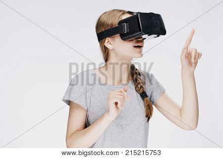 Beautiful young woman on white isolated background in virtual reality glasses.