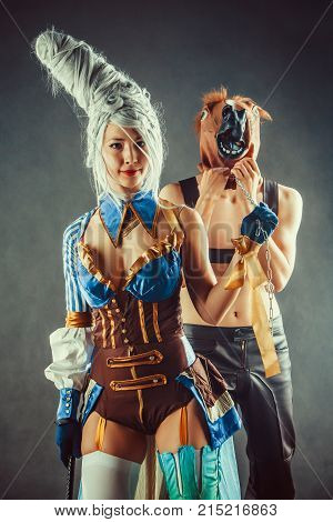 Young Couple In A Role Playing Game, Girl Is Holding A Man In The Horse Mask On The Chain.