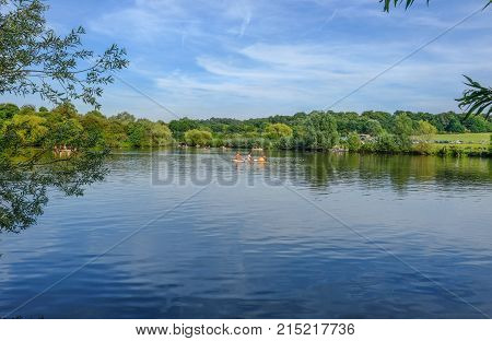 Hainault Forest Essex UK - August 28 2017: Girls in a rowing boat on the lake in the forest. Summer shot with beautiful color tones.