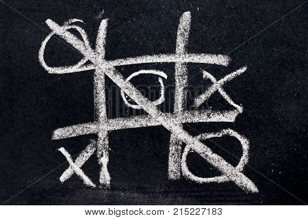 White chalk drawing as Tic Tac Toe with the winner and loser shape on black board background