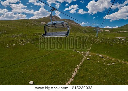 Aerial ropeway high in the mountains of Caucasus with grass plains and cow pastures in the background