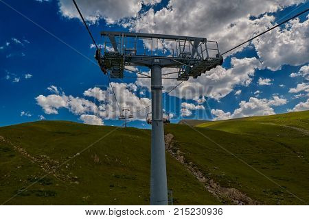 Aerial ropeway high in the mountains of Caucasus with grass plains and cow pastures in the background