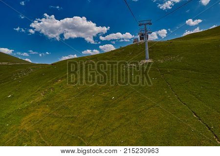 Aerial ropeway high in the mountains of Caucasus with grass plains and cow pastures in the background