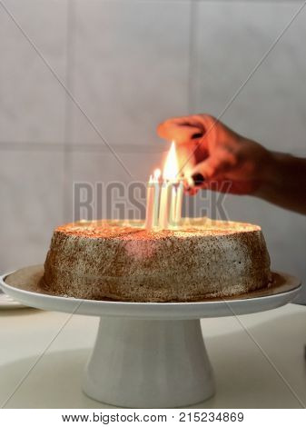 a hand lighting candles on a pie