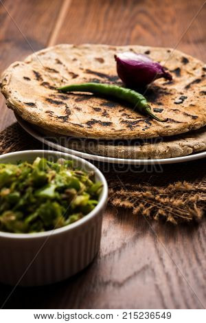Bajra roti or Jowar Roti or Indian bread made using Bajra or Jowar, served with green chilly thecha
