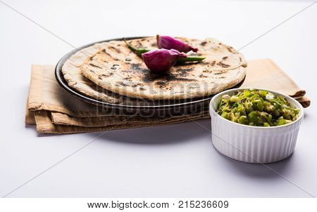 Bajra roti or Jowar Roti or Indian bread made using Bajra or Jowar, served with green chilly thecha
