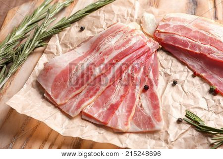 Rashers of bacon on wooden board, close up