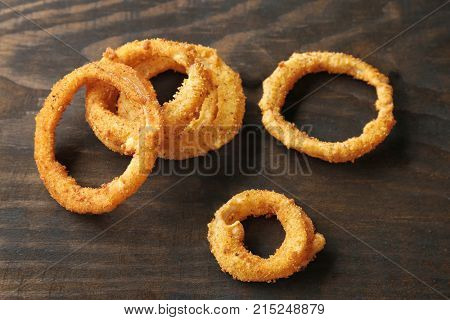 Fried breaded onion rings on wooden background