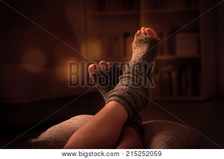 Woman's feet lying on pilow in the cozy room.
