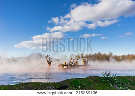 The river is far out of town in the morning mist
