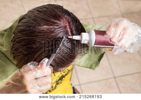 Woman Attempting To Apply Chemical Hair Color Onto Scalp