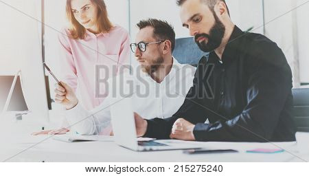 Coworkers at sunny office.Project managers team work new idea.Young businessmans working with startup modern studio.Blurred, film effect.Wid