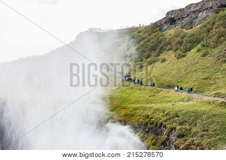 Tourists Walk Near Canyon Of Gullfoss Waterfall
