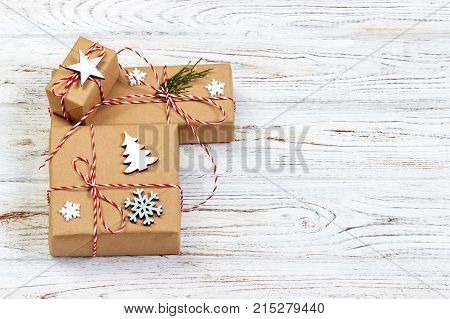 Three Festive Boxes in craf Paper Decorated with Snowflakes and star on Wooden Table. Top View.