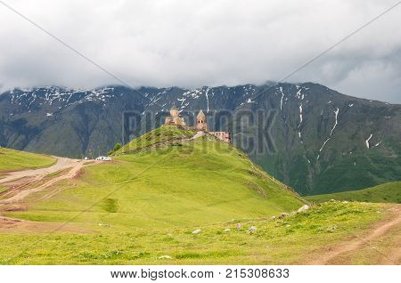 Holy Trinity Church in Georgia. Under Mount Kazbegi. Spring Or Summer Season.