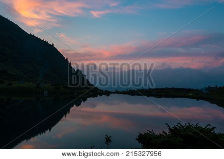 Landscape on the shore of the lake in the Carpathians mountains before sunset
