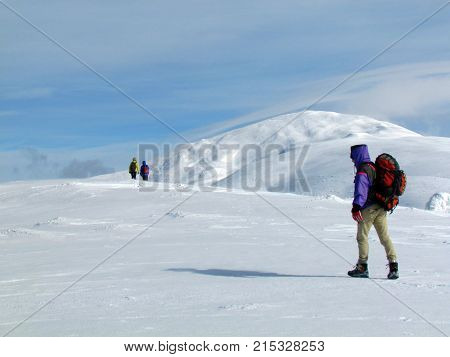 Landscape of the winter Carpathians mountains with three travellers