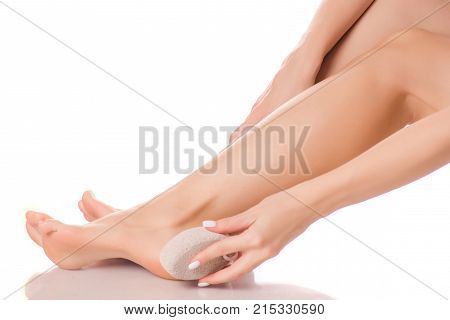 Female feet heel stone pumice on white background isolation