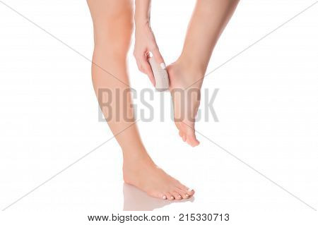 Female feet heel stone pumice on white background isolation