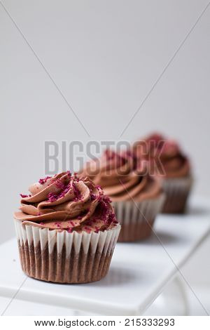Three chocolate cupcakes on a white background