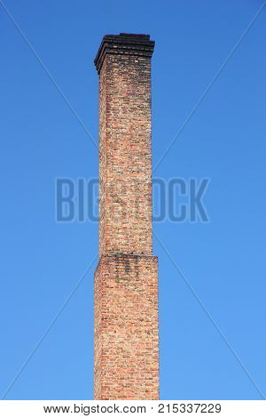 one orange brick pipe on blue sky. environmental construction concept