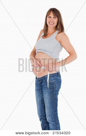 Donna incinta Loooking buona misura suo ventre stando in piedi