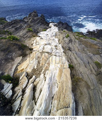 White Stone Streak That Empties Into The Sea On A Cliff Of Gray Stones Called 