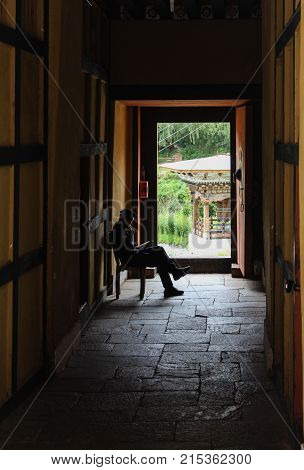 Thimphu, Bhutan - September 11, 2016: Buddhist Guard Sitting At The Doorway In The Shadow At Simtokh