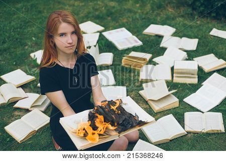 A Girl Holding A Book Burning In Nature In Summer Garden