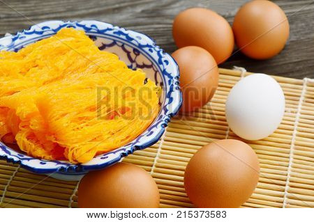 Golden egg strip is Thai desserts made from eggs with Thai style bowl on wooden background