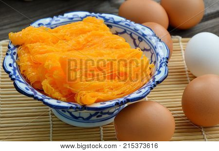 Golden egg strip is Thai desserts made from eggs with Thai style bowl on wooden background