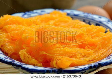Golden egg strip is Thai desserts made from eggs with Thai style bowl on wooden background