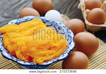 Golden egg strip is Thai desserts made from eggs with Thai style bowl on wooden background